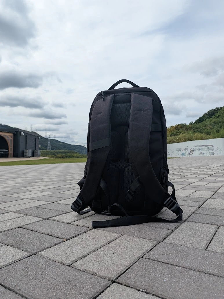 屋外の石畳の上に置いたABLE CARRY Daily Plusの背面とショルダーストラップ
