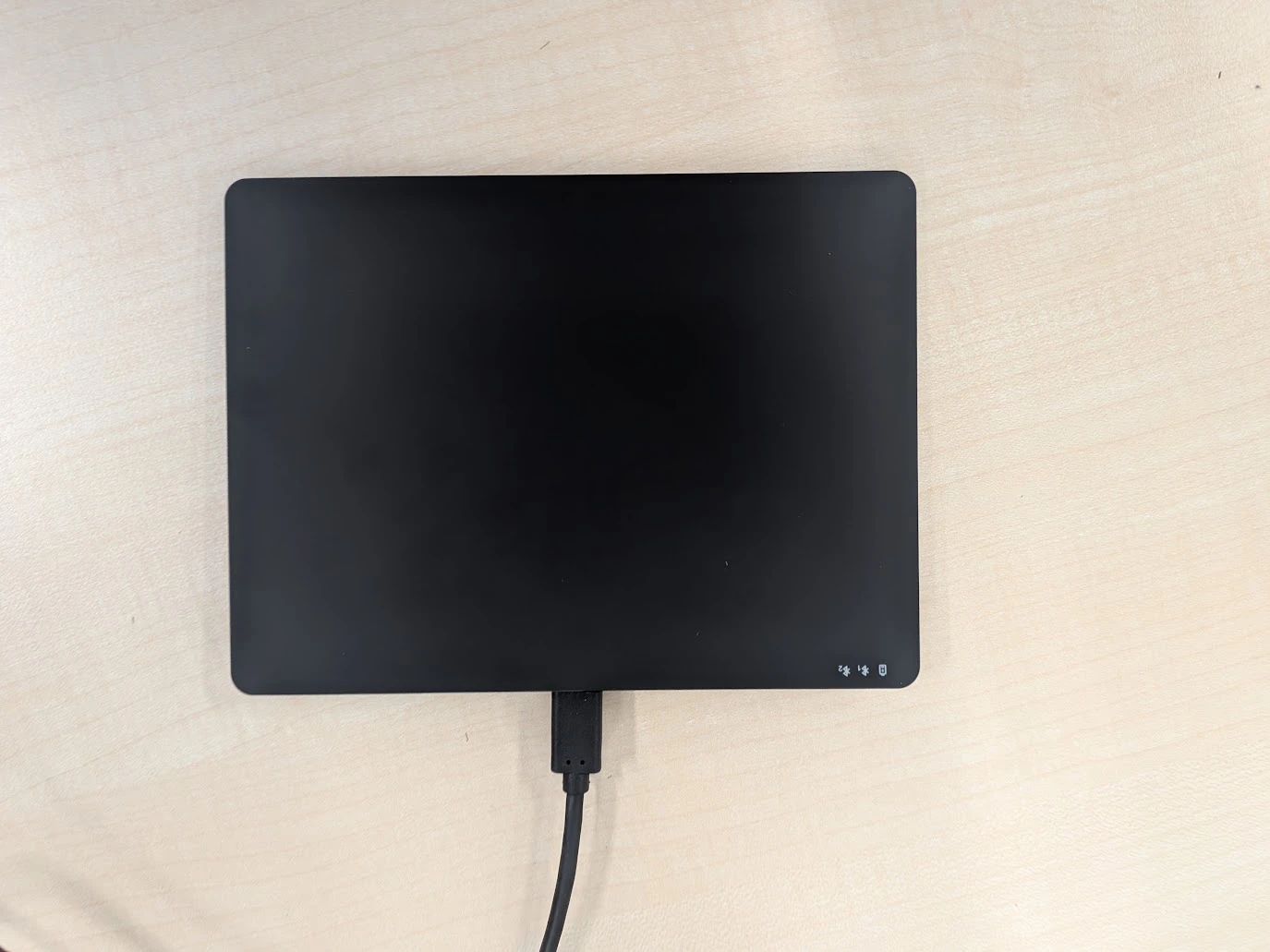 上から見たトラックパッドと、つないだUSB-Cケーブル