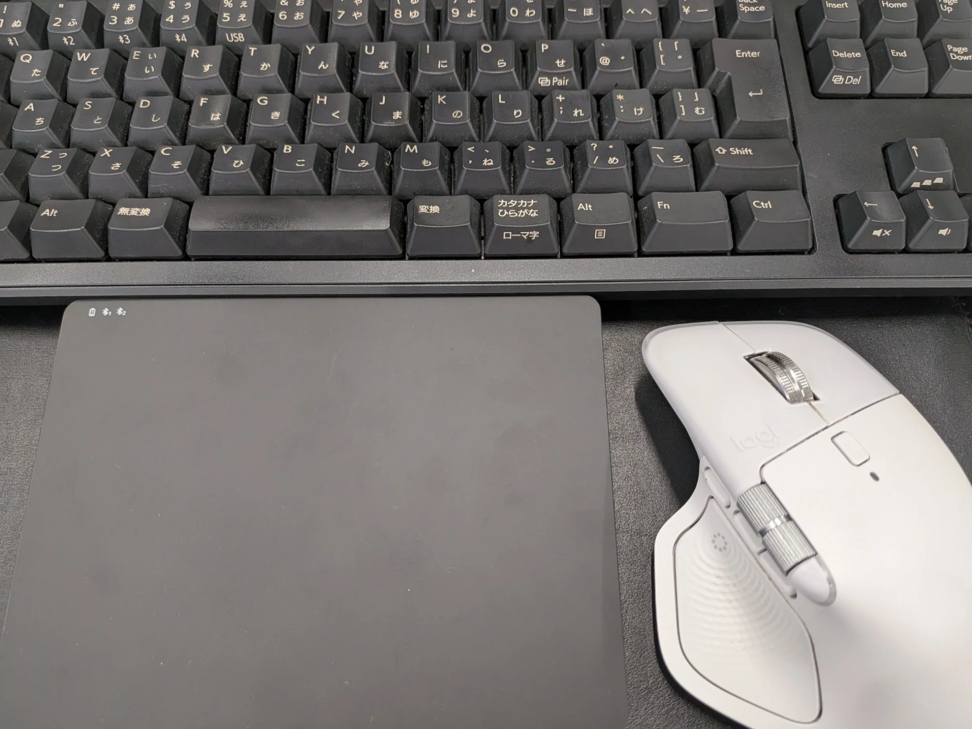 キーボードの手前にトラックパッド、右にMX Master 4を置いたデスク